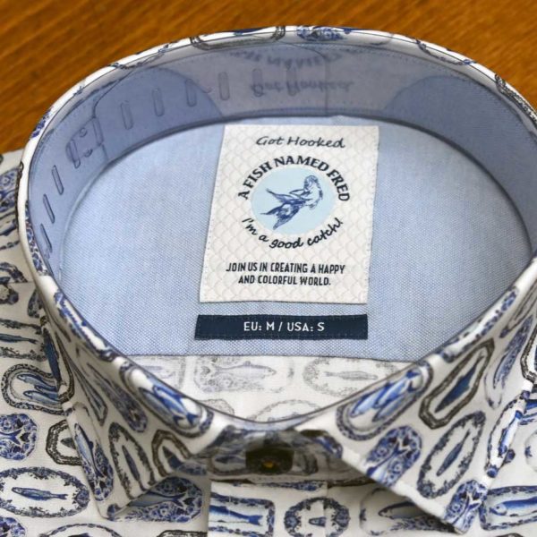 A Fish Named Fred shirt with blue fish on plates on white cotton.