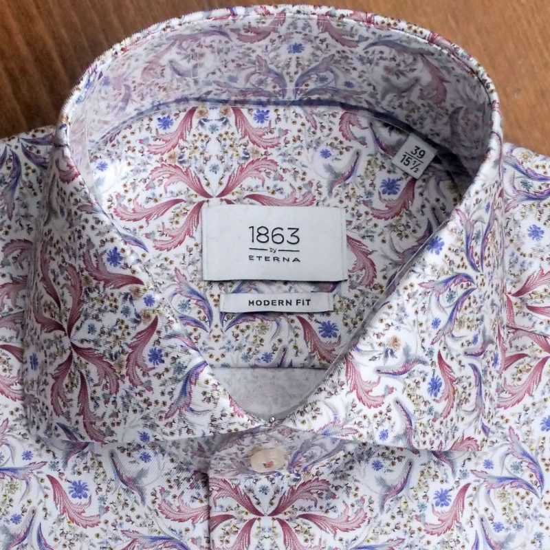 Eterna shirt with red leaves and blue foliage on white.