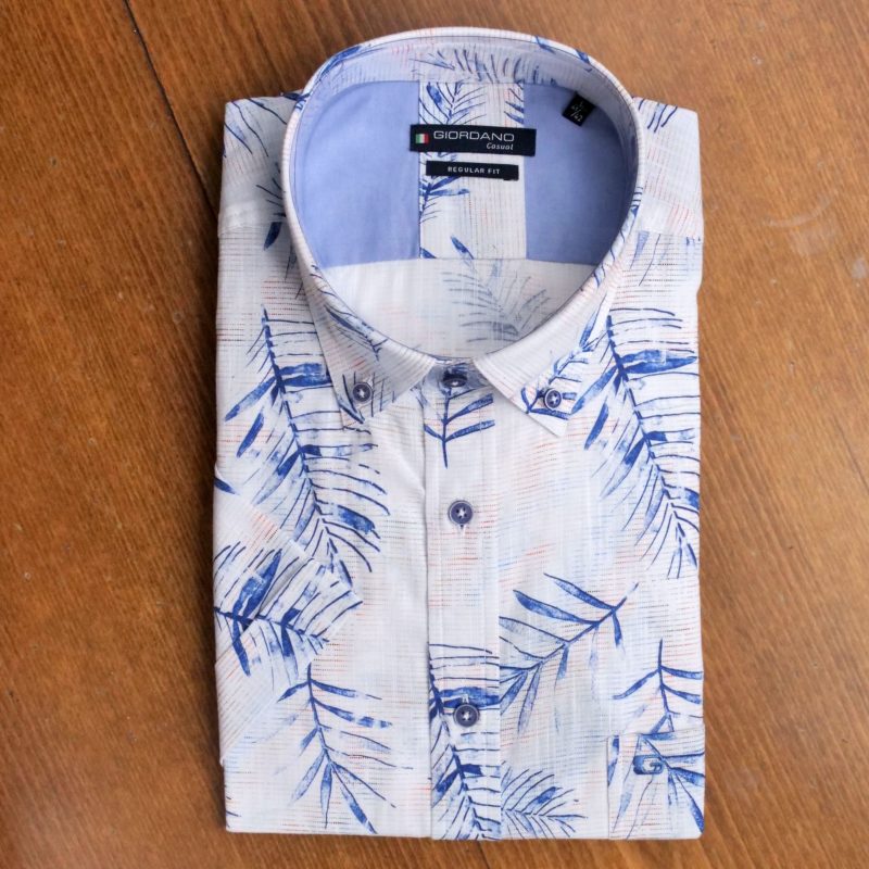 Giordano shirt with blue ferns on a faint red and blue pattern on white.