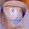 R2 white shirt with tiny white cups on brown saucers on a dark blue background