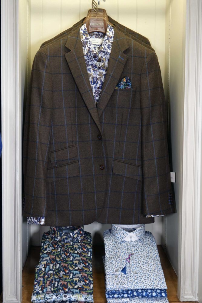 Display of shirts, suits and jumpers at Gabucci Menswear in Bath